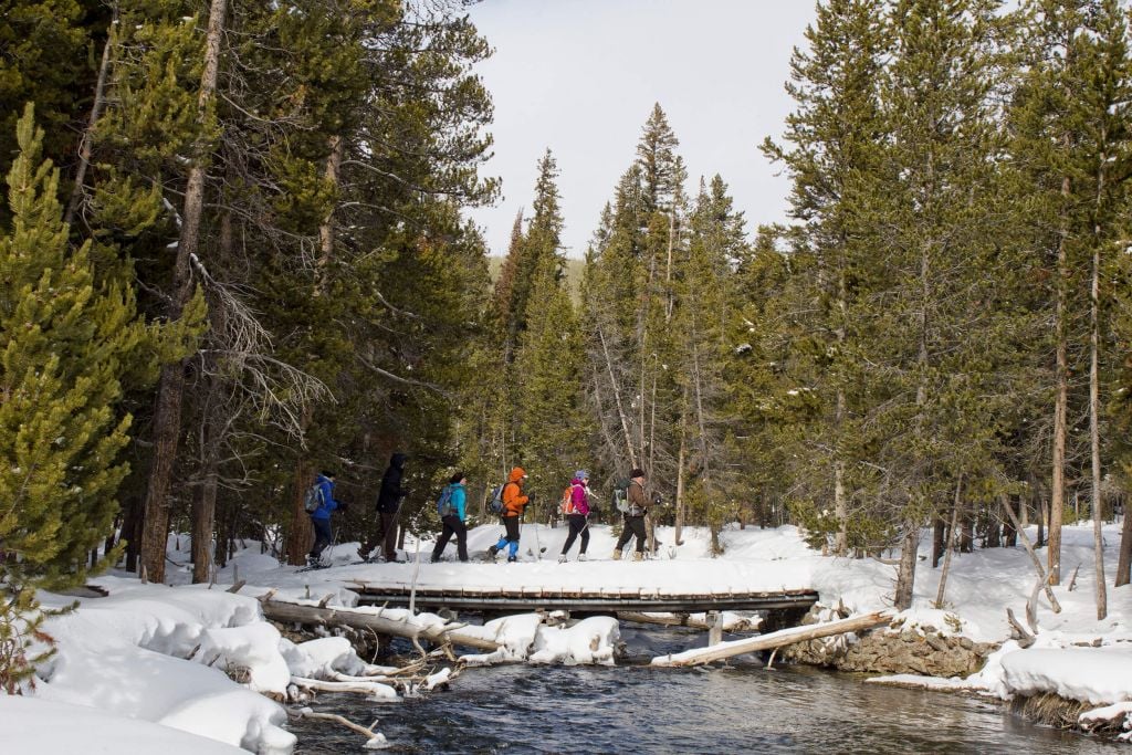 Snowshoe tour crossing stream