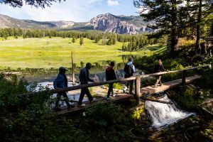 Hikers crossing bridge in front of Trout lake