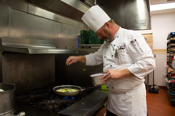 A chef prepares a meal on the stove