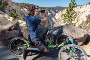 A person in an off-road wheelchair Photographing Lower Falls at Artist Point