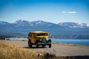 Historic Yellow Bus driving along Yellowstone Lake