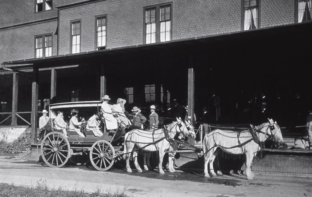 Stagecoach with passengers in front of a building