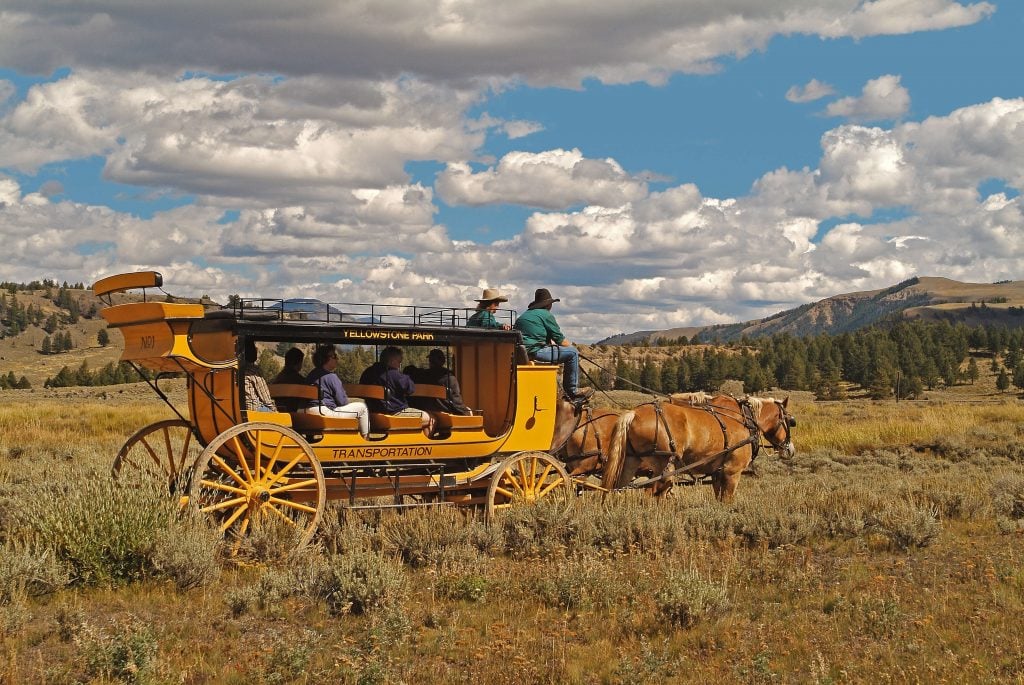 New stagecoach with passengers in a field