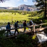 Hikers crossing bridge in front of Trout lake