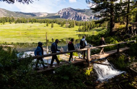 Hikers crossing bridge in front of Trout lake