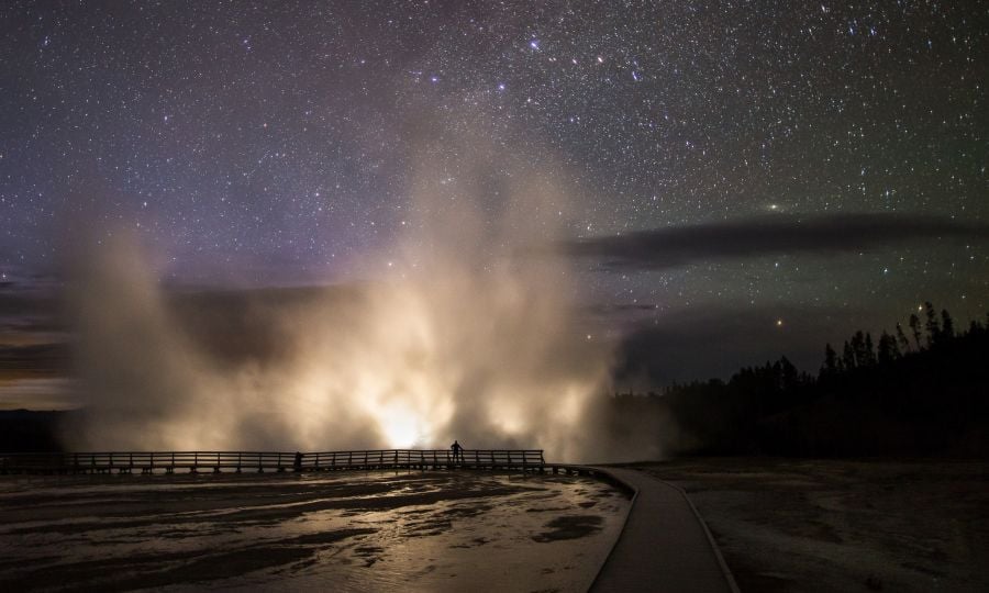 Car headlights illuminate the steam plume from Excelsior Geyser in the Midway Geyser Basin