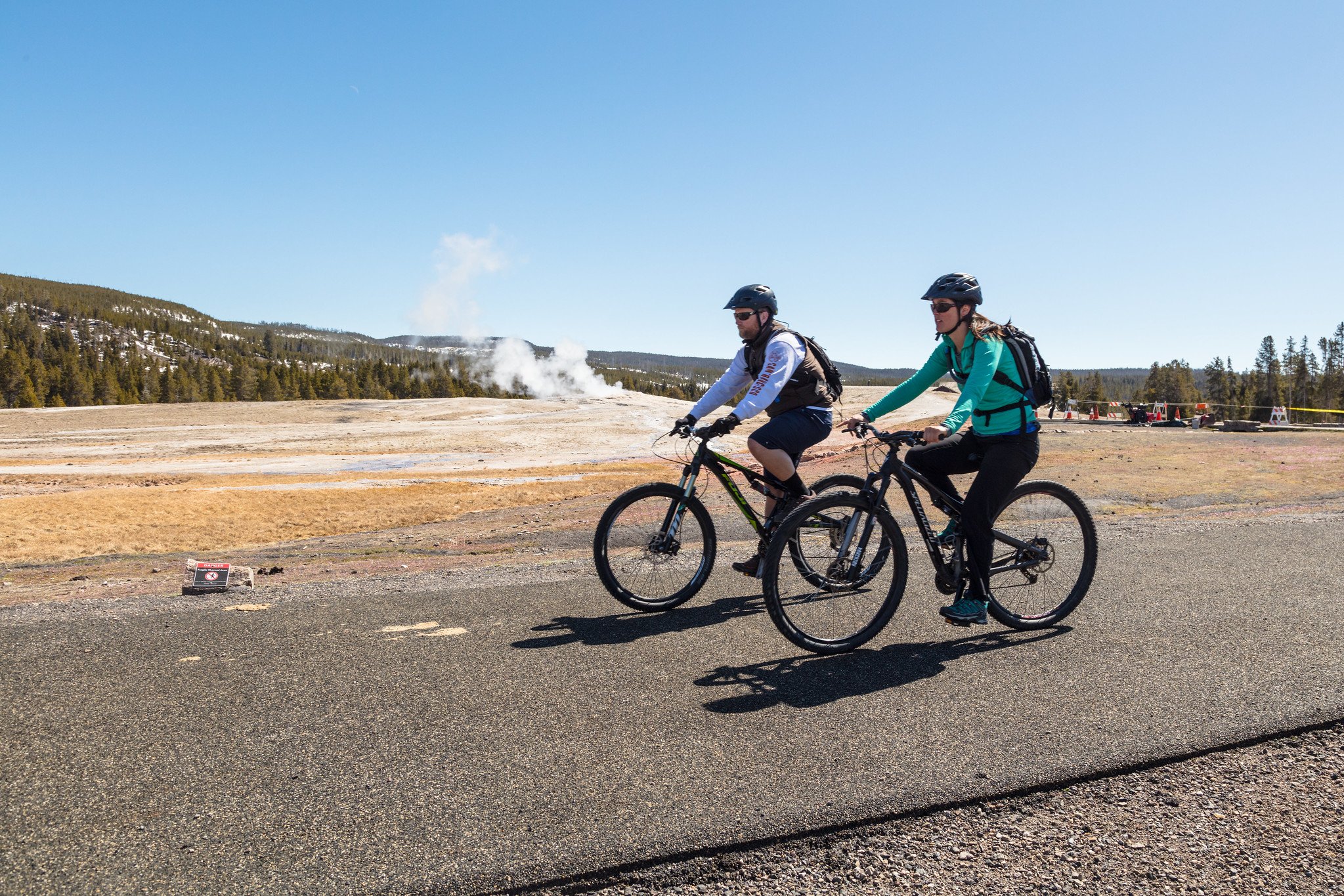 https://www.yellowstonenationalparklodges.com/content/uploads/2017/05/Cyclists-at-Old-Faithful.jpg