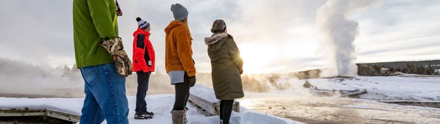 People watching old faithful geyser in winter