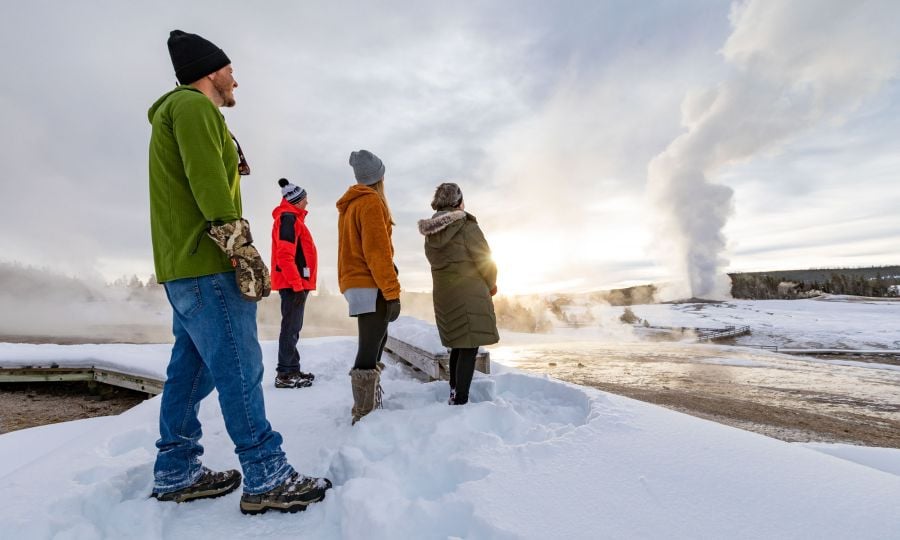 People watching old faithful geyser in winter