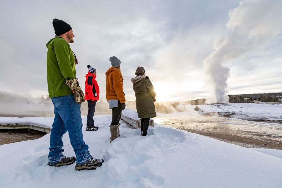 People watching old faithful geyser in winter