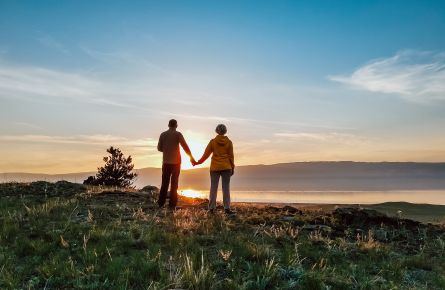 Silhouette of couple on top of a mountain