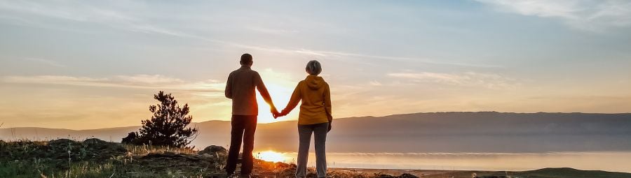 Silhouette of couple on top of a mountain