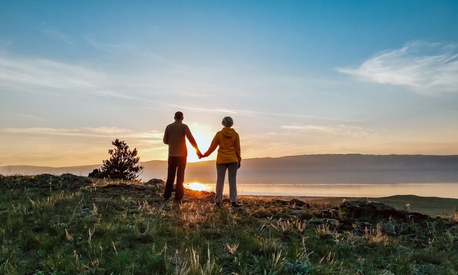 Silhouette of couple on top of a mountain