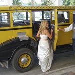 Bride getting into a historic yellow bus