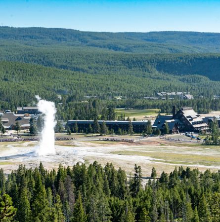 Old Faithful Geyser erupts with Old Faithful Inn in the background