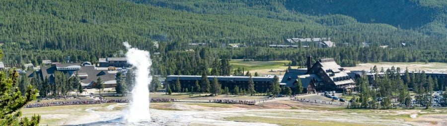 Old Faithful Geyser erupts with Old Faithful Inn in the background