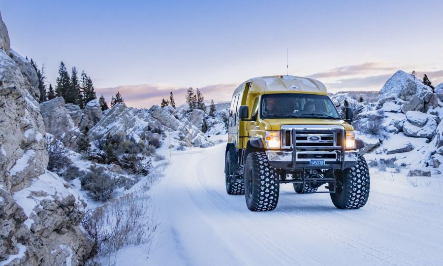 Snowcoach driving through the hoodoos