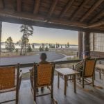 Two people in rocking chairs on the porch of Lake Lodge Cabins