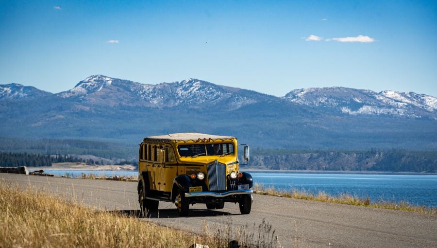 Historic Yellow Bus driving along Yellowstone Lake