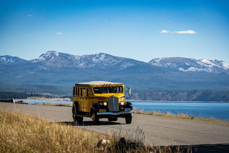 Historic Yellow Bus driving along Yellowstone Lake