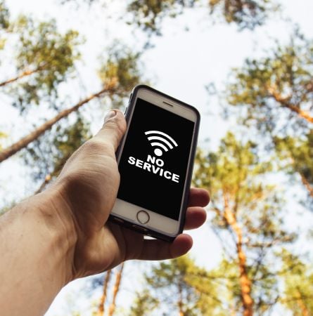 Hand is holding a phone with sign no service