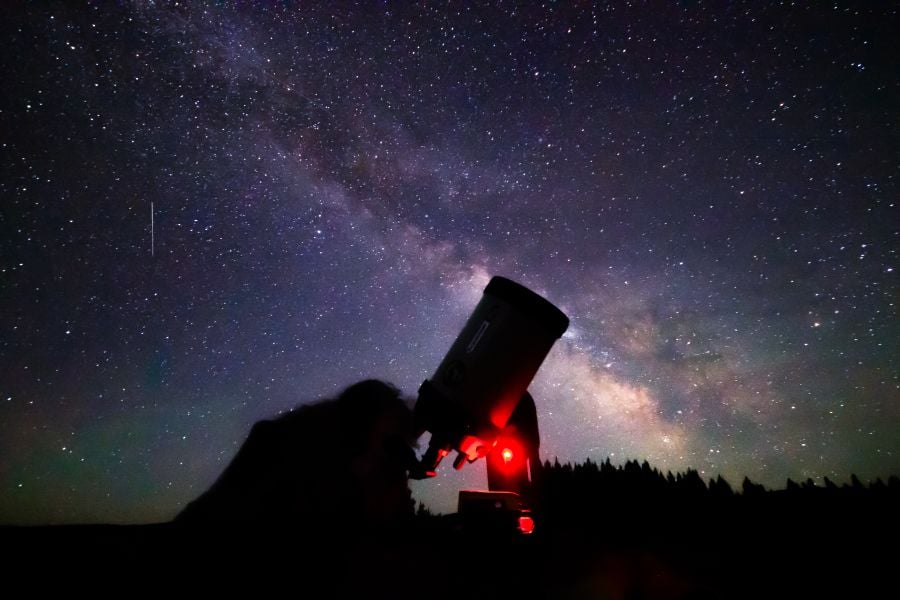 Person viewing the Milky Way from a telescope